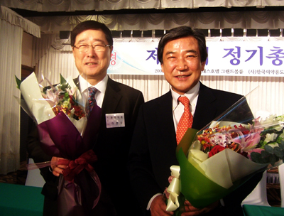 당선인 발표후 이한우(왼쪽) 당선자와 황치엽 후보가 함께 꽃다발을 받으며 업계화합을 다짐했다.