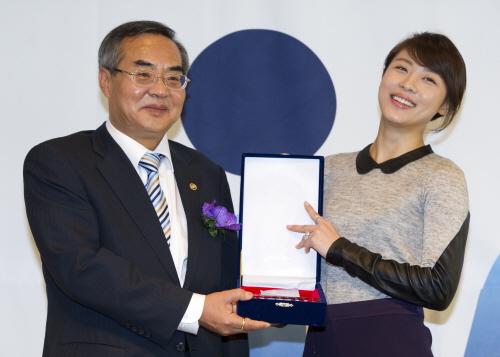 손건익 복지부차관(왼쪽)이 메디칼 코리아 2011, 나눔의료 기념행사에서 연예인 하지원 씨(오른쪽)에게 감사패를 전달하고 있다.