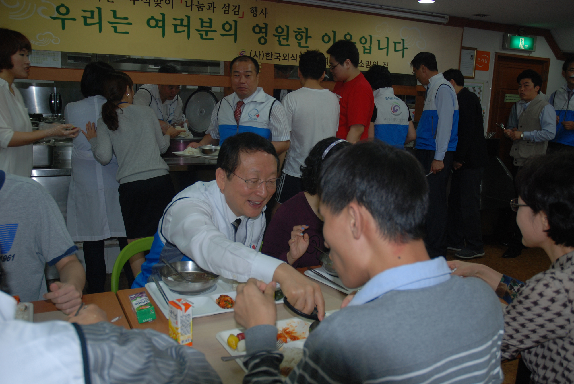 (사)한국외식업중앙회(회장 남상만-사진 가운데) '음식과 사랑 봉사단'은 추석 맞이 전국 동시다발 행사로 2억1600여만원을 투입해 불우이웃돕기 봉사활동을 전개한다.<사진에 남상만 외식업중앙회장이 정성껏 준비한 음식을 소망의 집 원생에게 웃음을 머금은 채 건네주고 있다.>