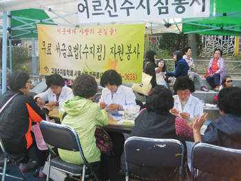 서울서부지회 봉사단원들이 주민들에게 서금요법 봉사를 실시하고 있다.